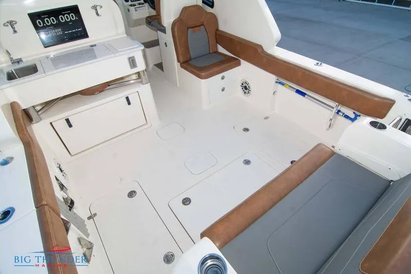 Yacht Photos Pics 2022 Scout 350 LXZ boat interior with brown seating and modern dashboard.