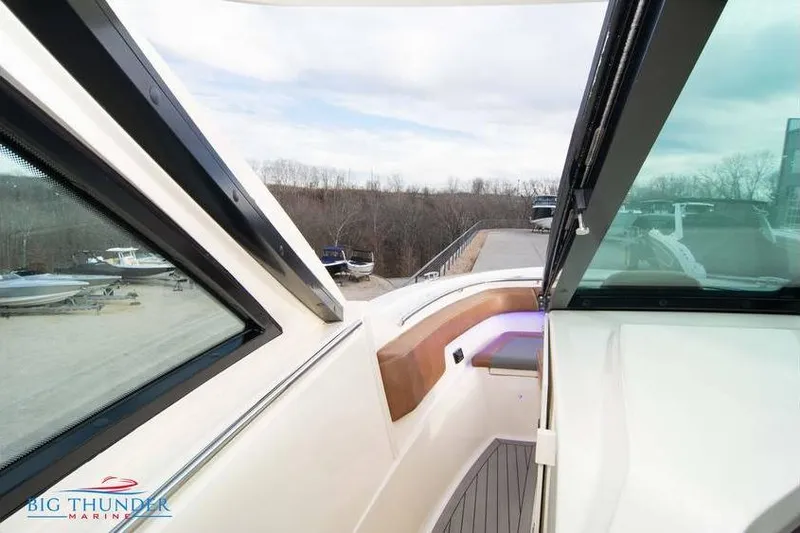  Yacht Photos Pics 2022 Scout 350 LXZ boat interior with seating, glass windows, and outdoor view.