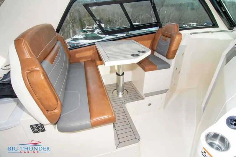  Yacht Photos Pics 2022 Scout 350 LXZ boat interior with brown leather seating and table.