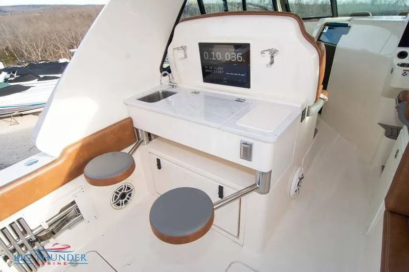  Yacht Photos Pics 2022 Scout 350 LXZ boat interior with seating, sink, and control panel.