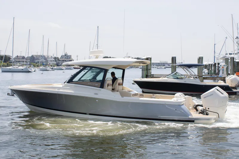  Yacht Photos Pics 2025 Chris-Craft Calypso 32 boat cruising in a marina with other boats nearby.