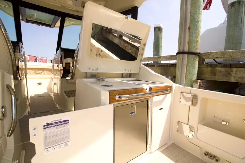  Yacht Photos Pics 2025 Chris-Craft Calypso 32 boat interior with kitchenette and seating area.