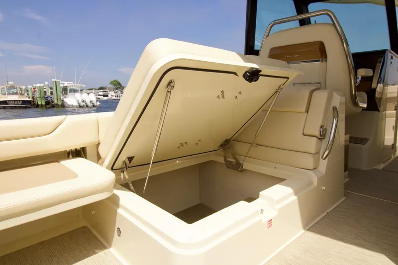  Yacht Photos Pics 2025 Chris-Craft Calypso 32 boat interior with open storage compartment, docked at marina.