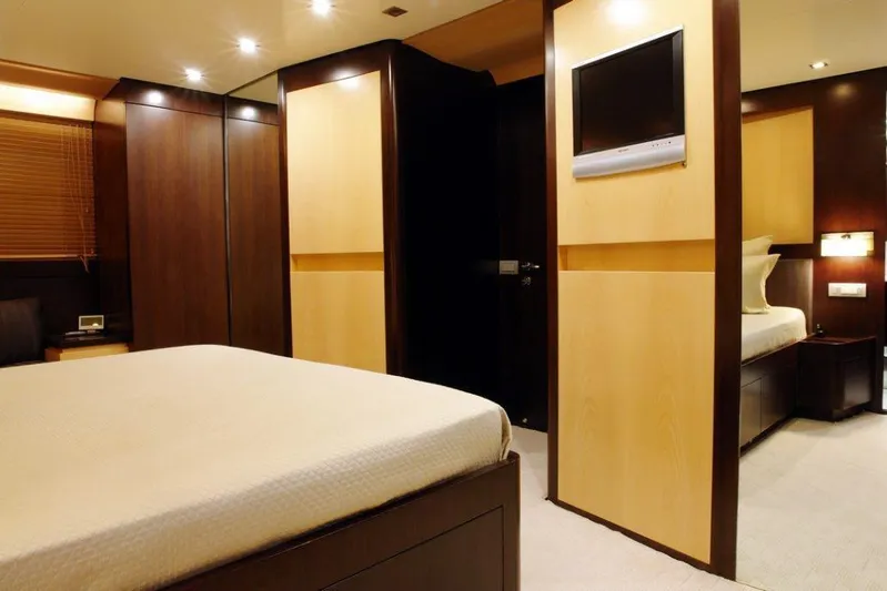  Yacht Photos Pics Luxurious bedroom interior of 2006 Sanlorenzo SL88 yacht with modern furnishings and built-in TV.