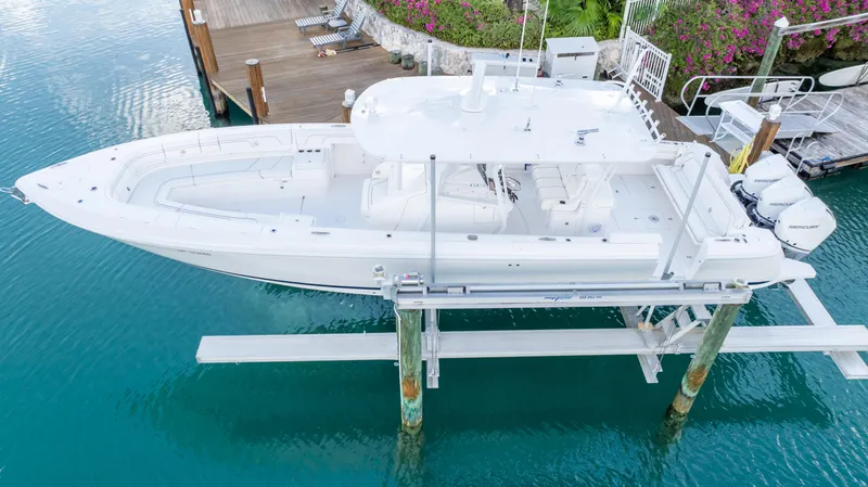  Yacht Photos Pics 2019 Intrepid 400 Center Console boat docked on a lift in clear blue water.