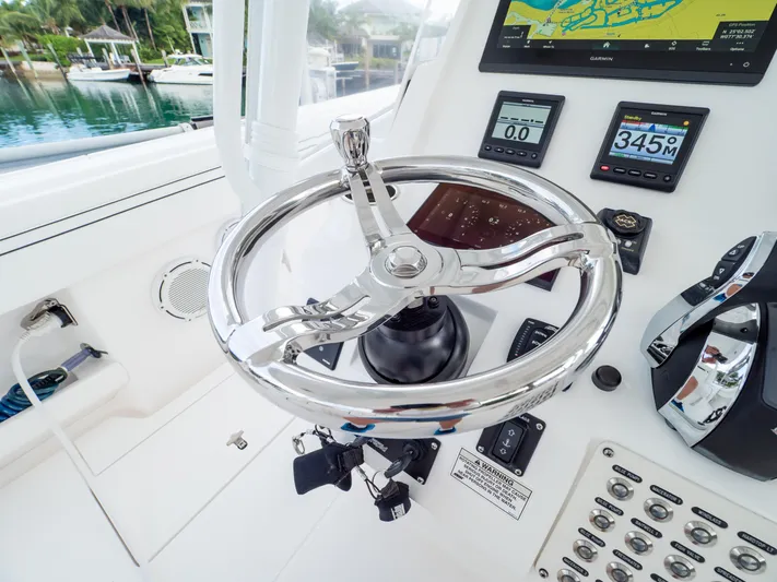  Yacht Photos Pics 2019 Intrepid 400 Center Console helm with chrome steering wheel and navigation displays.