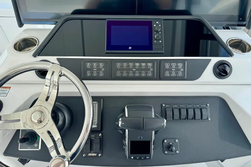  Yacht Photos Pics Control panel of 2026 Intrepid 50 Evolution boat with steering wheel and navigation controls.