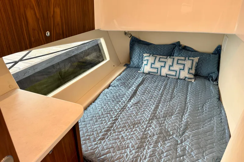  Yacht Photos Pics Cozy cabin interior of 2026 Intrepid 50 Evolution with blue bedding and geometric pillows.