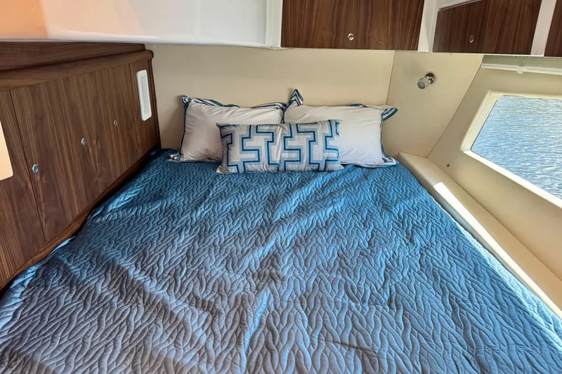  Yacht Photos Pics Luxurious cabin interior of 2026 Intrepid 50 Evolution yacht with blue bedding.
