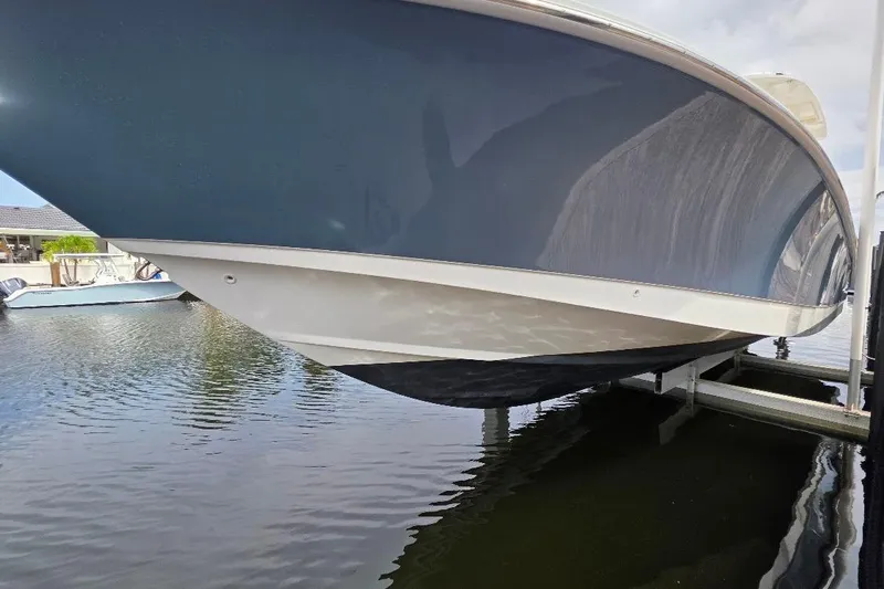  Yacht Photos Pics 2016 Boston Whaler 370 Outrage boat on lift, reflecting on calm water.