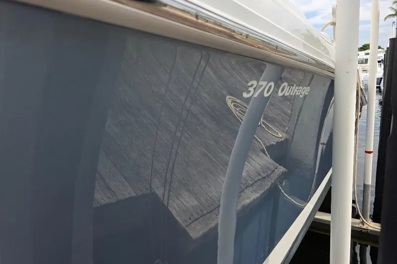  Yacht Photos Pics 2016 Boston Whaler 370 Outrage boat docked, reflecting wooden deck.