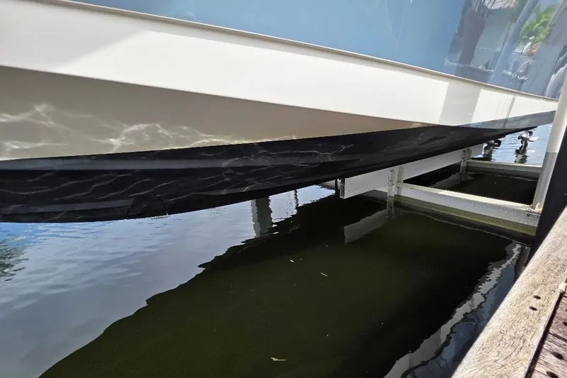  Yacht Photos Pics 2016 Boston Whaler 370 Outrage boat hull on a lift over water.