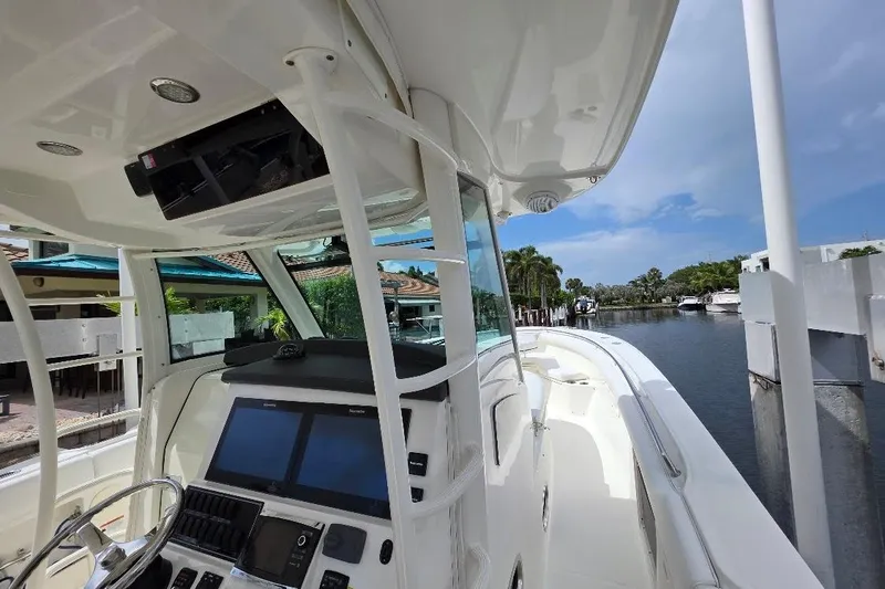  Yacht Photos Pics 2016 Boston Whaler 370 Outrage boat interior with navigation system, docked by waterfront homes.