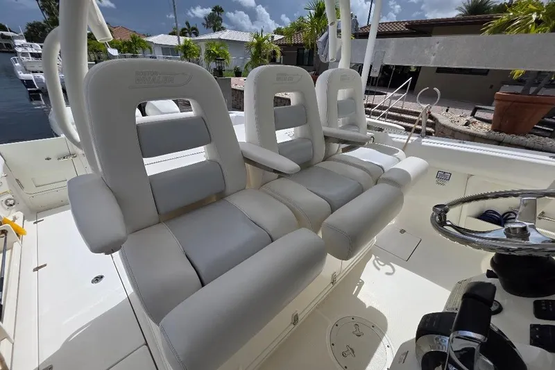  Yacht Photos Pics 2016 Boston Whaler 370 Outrage boat interior with plush seating and steering wheel.