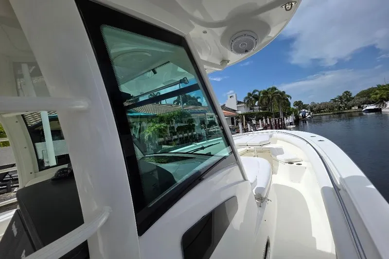  Yacht Photos Pics 2016 Boston Whaler 370 Outrage boat docked by a scenic waterfront.