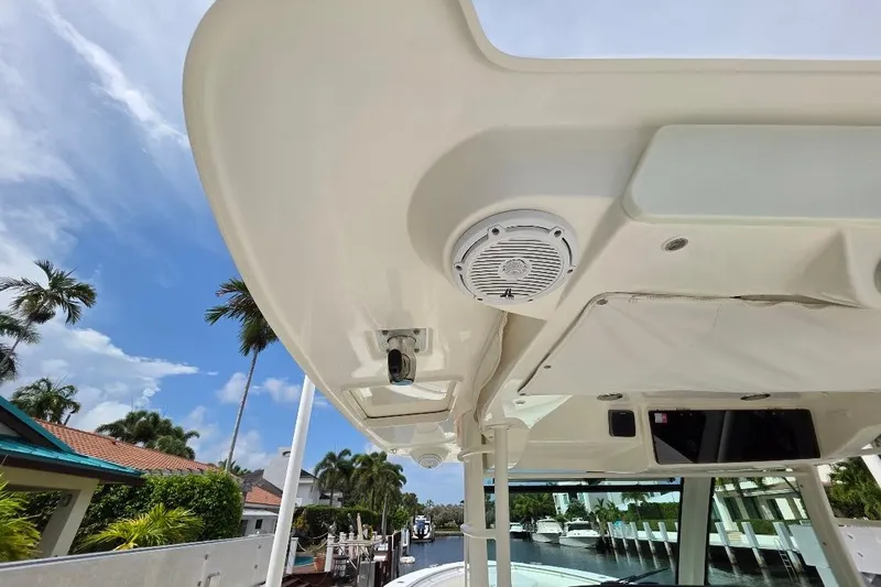  Yacht Photos Pics 2016 Boston Whaler 370 Outrage boat interior, featuring speakers and canopy under a clear sky.