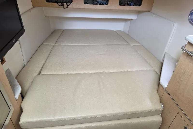 Yacht Photos Pics 2016 Boston Whaler 370 Outrage cabin interior with beige cushioned bed.