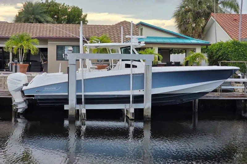  Yacht Photos Pics 2016 Boston Whaler 370 Outrage docked by waterfront home with palm trees.