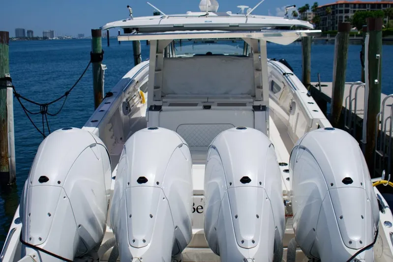 W7 Yacht Photos Pics 2022 Pursuit S 428 Sport boat with four powerful outboard engines docked at marina.