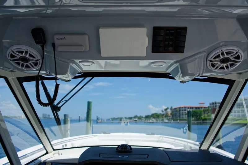 W7 Yacht Photos Pics 2022 Pursuit S 428 Sport boat interior with speakers and navigation equipment, overlooking marina.
