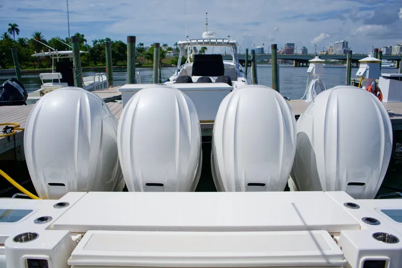 W7 Yacht Photos Pics 2022 Pursuit S 428 Sport boat with four powerful outboard engines docked at marina.