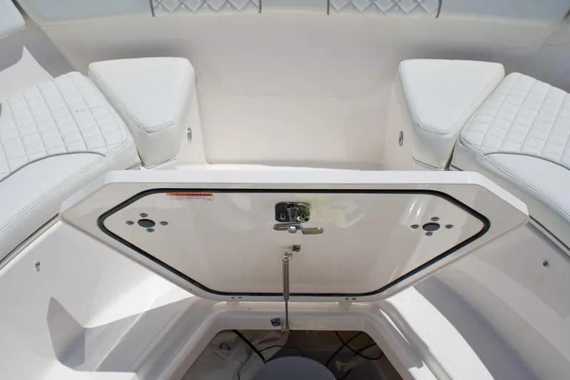 W7 Yacht Photos Pics 2022 Pursuit S 428 Sport boat interior with open storage compartment and cushioned seating.
