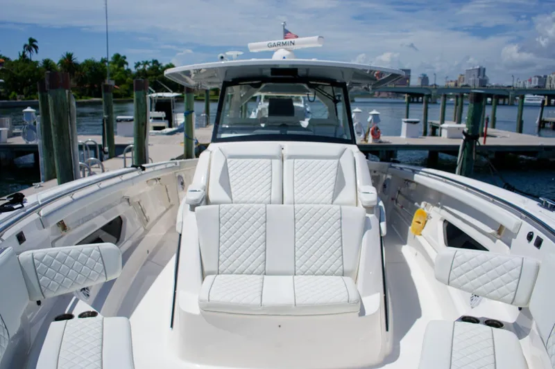 W7 Yacht Photos Pics 2022 Pursuit S 428 Sport boat with luxurious seating at a marina.