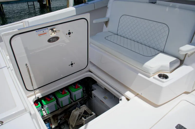 W7 Yacht Photos Pics 2022 Pursuit S 428 Sport boat interior with battery compartment and cushioned seating.