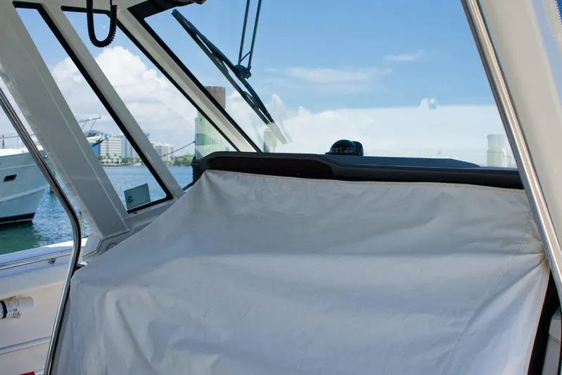 W7 Yacht Photos Pics 2022 Pursuit S 428 Sport boat interior with covered dashboard, docked in marina.