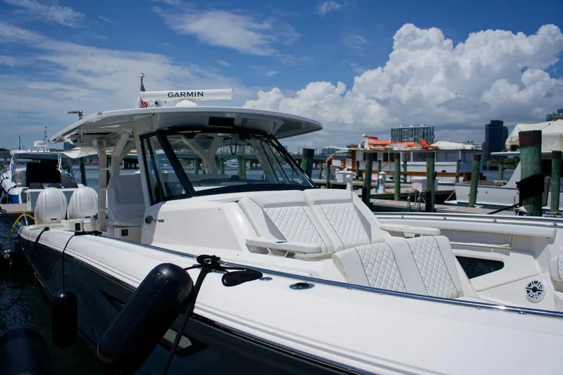 W7 Yacht Photos Pics 2022 Pursuit S 428 Sport boat docked, featuring sleek design and luxurious seating.