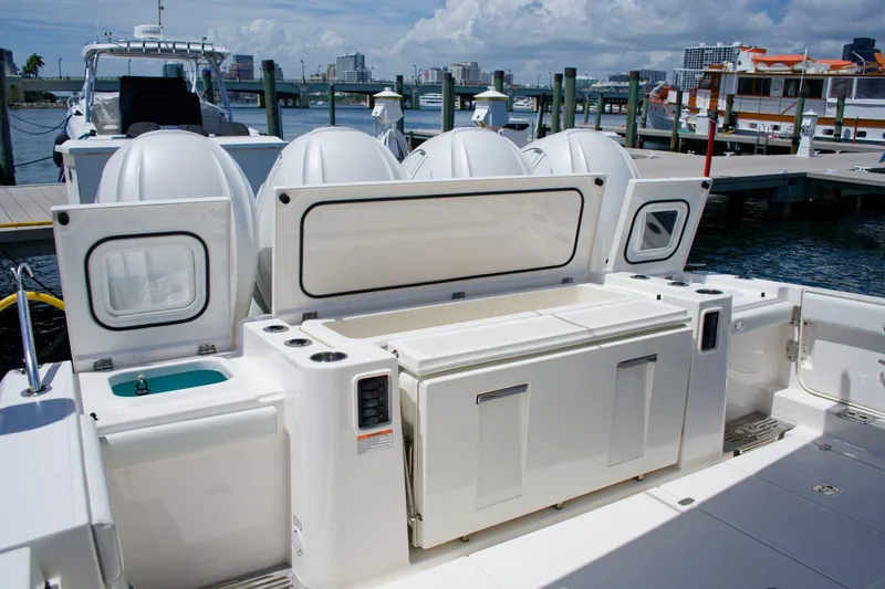 W7 Yacht Photos Pics 2022 Pursuit S 428 Sport boat at dock with open storage compartments.