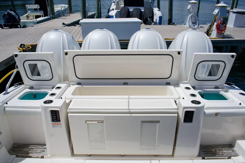 W7 Yacht Photos Pics 2022 Pursuit S 428 Sport boat with open storage compartments and four engines at dock.