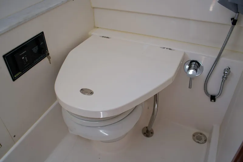 W7 Yacht Photos Pics 2022 Pursuit S 428 Sport boat bathroom with modern toilet and shower controls.