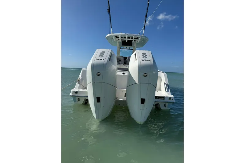  Yacht Photos Pics 2024 Boston Whaler 280 Outrage with dual engines in clear blue water.