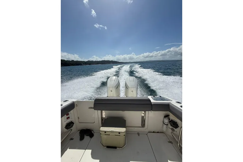  Yacht Photos Pics 2024 Boston Whaler 280 Outrage cruising on open water under clear skies.