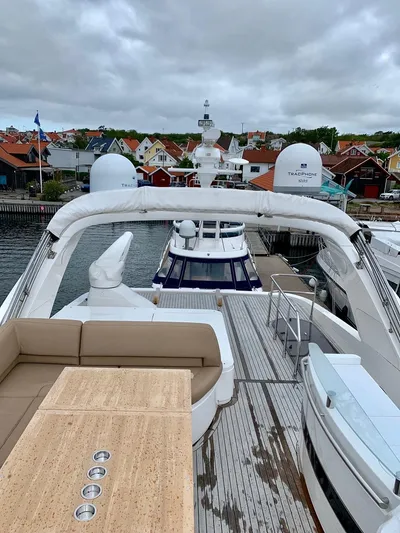  Yacht Photos Pics 2010 Princess 72 Motor Yacht docked in a scenic harbor with overcast skies.