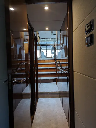  Yacht Photos Pics Interior hallway of a 2010 Princess 72 Motor Yacht with wooden finishes and carpeted flooring.