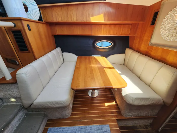  Yacht Photos Pics Interior of 2000 Silverton 442 Cockpit Motor Yacht with cozy seating and wooden table.