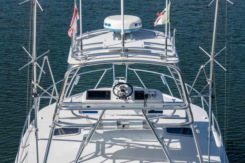  Yacht Photos Pics 2005 Cabo 40 Express boat with tower and navigation equipment on calm water.