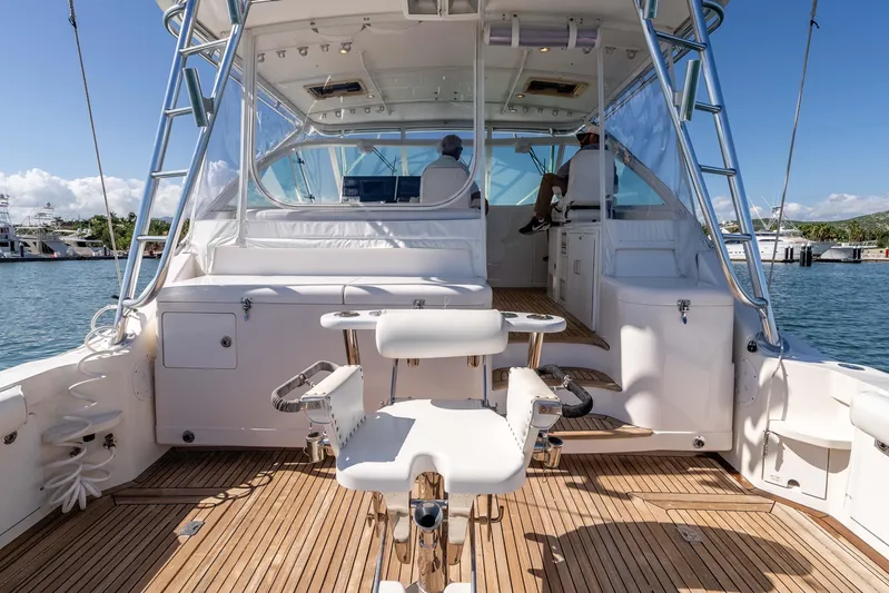  Yacht Photos Pics 2005 Cabo 40 Express yacht with spacious deck and fishing chair, docked in sunny marina.