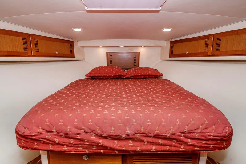  Yacht Photos Pics 2005 Cabo 40 Express cabin with cozy bed and wooden storage cabinets.