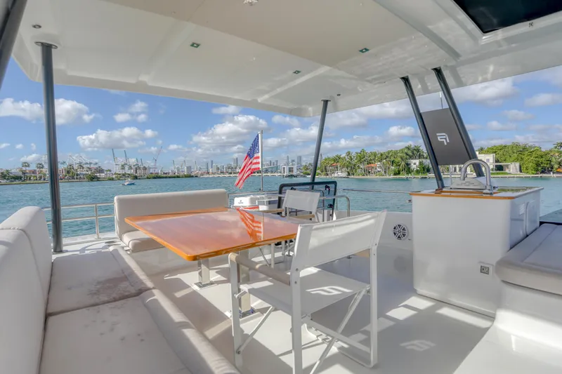 Hawkeye Yacht Photos Pics Luxurious 2022 Fountaine Pajot MY6 yacht deck with seating, table, and ocean view.