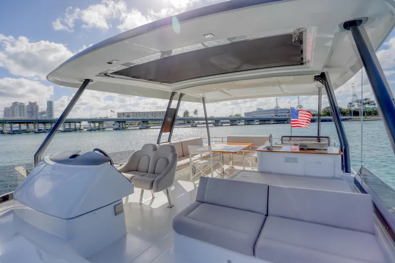 Hawkeye Yacht Photos Pics Luxurious 2022 Fountaine Pajot MY6 yacht interior with seating, table, and scenic water view.