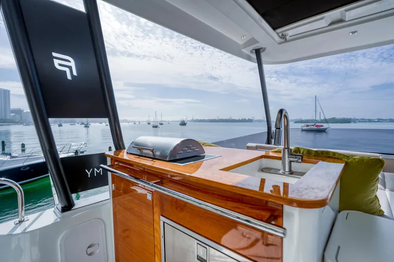 Hawkeye Yacht Photos Pics Luxury Fountaine Pajot MY6 yacht with sleek outdoor kitchen, overlooking serene marina.