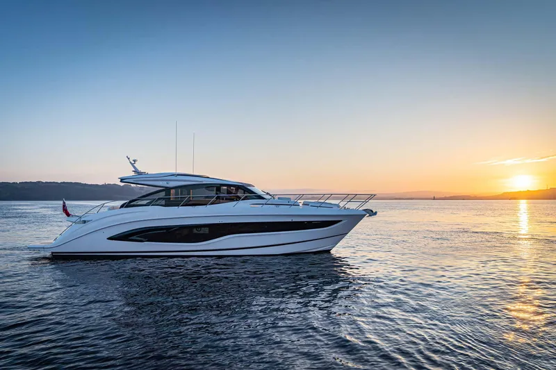  Yacht Photos Pics 2025 Princess V55 Express yacht cruising at sunset on calm waters.