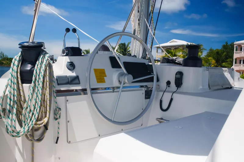 Point Clear Yacht Photos Pics Steering wheel of 2023 Bali 4.4 yacht with ropes and controls, under clear blue sky.