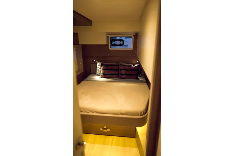 Point Clear Yacht Photos Pics Cozy cabin interior of 2023 Bali 4.4 yacht with striped pillows and small window.