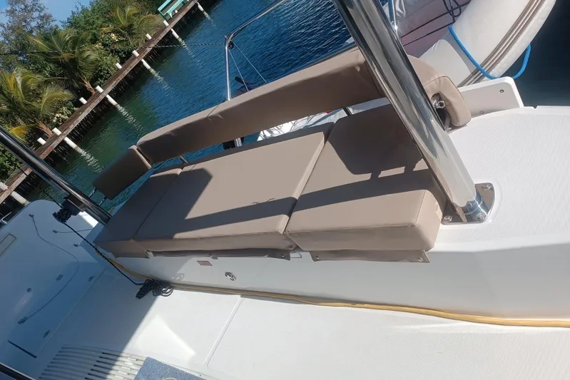 Point Clear Yacht Photos Pics Luxury seating on 2023 Bali 4.4 yacht, docked by tropical waterfront.
