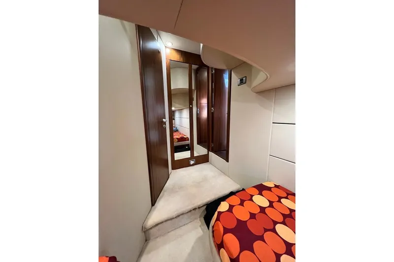  Yacht Photos Pics Interior of 2006 Sunseeker Portofino 47 yacht with wood paneling and vibrant bedding.