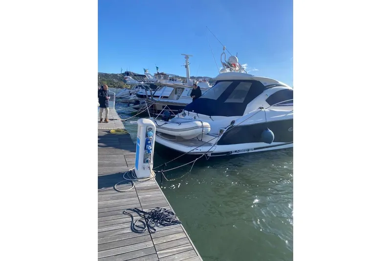  Yacht Photos Pics 2006 Sunseeker Portofino 47 yacht docked at marina under clear blue sky.